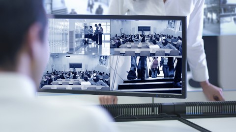 Operator looking at his desktop that has multiple video surveillance